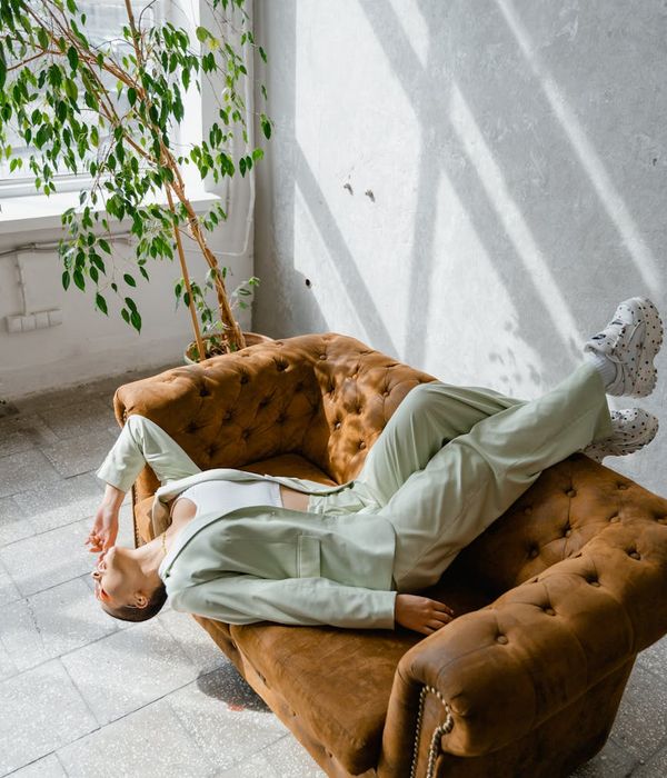 Person meditating peacefully in a bright, sunlit room.